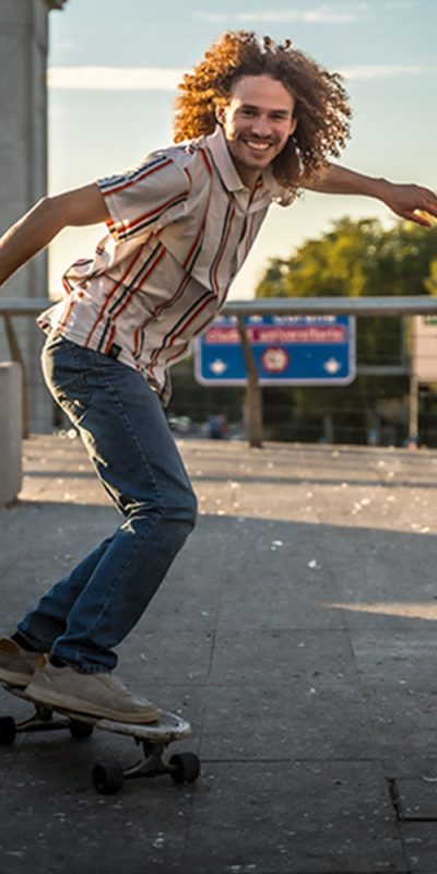 man-with-curly-hair-skating-along-the-city-2025-06-02-00-10-02-utc Decked Skater